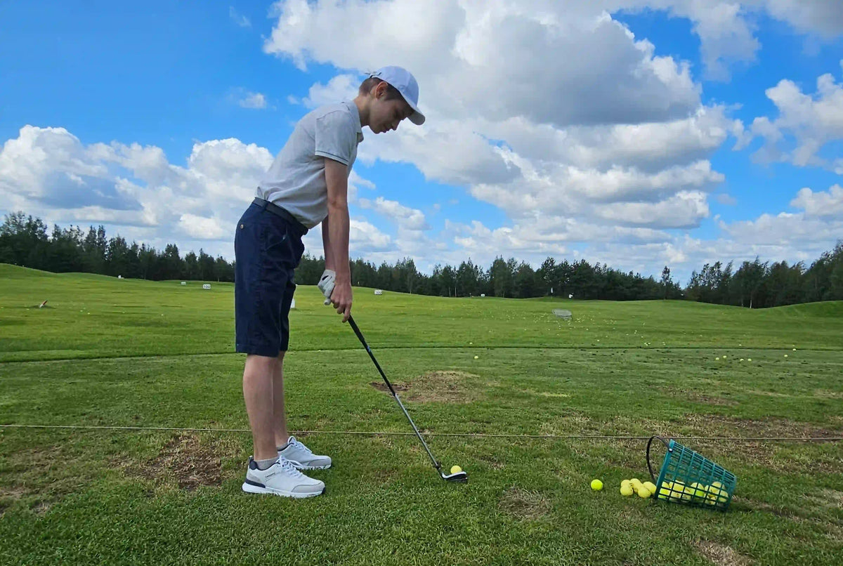 young golfer practicing swing driving range